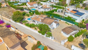 A residential area with houses, a swimming pool, and a street. - Villa Mona - PlusHolidays (Calpe)