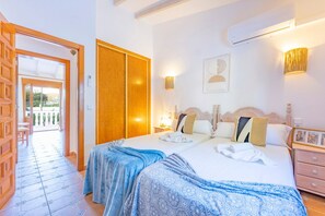 A hotel room with a double bed, a wardrobe, a bedside table, a nightstand, and a view of the outside.