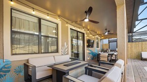 An outdoor seating area with a sofa and chairs, string lights, and a ceiling fan. - Royal Retreat: All Inclusive Champions Gate Resort 6BD6BA Free Heated Pool Villa (Four Corners)