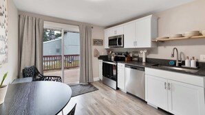 Una cucina moderna con mobili bianchi, un forno a microonde integrato e un lavello.