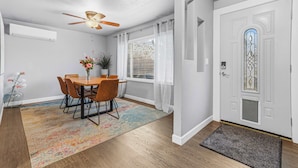 Un espace repas comprenant une table, des chaises, un ventilateur de plafond et une fenêtre avec des stores.