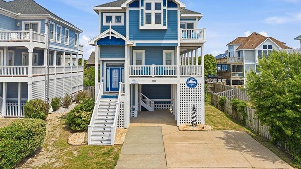 A two-story house with a balcony, a front porch, and a staircase leading to the entrance.