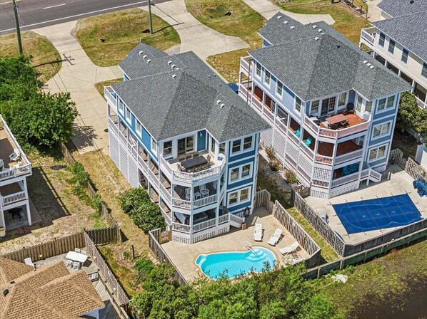 Un edificio residencial de varios pisos con piscina y cancha de tenis.