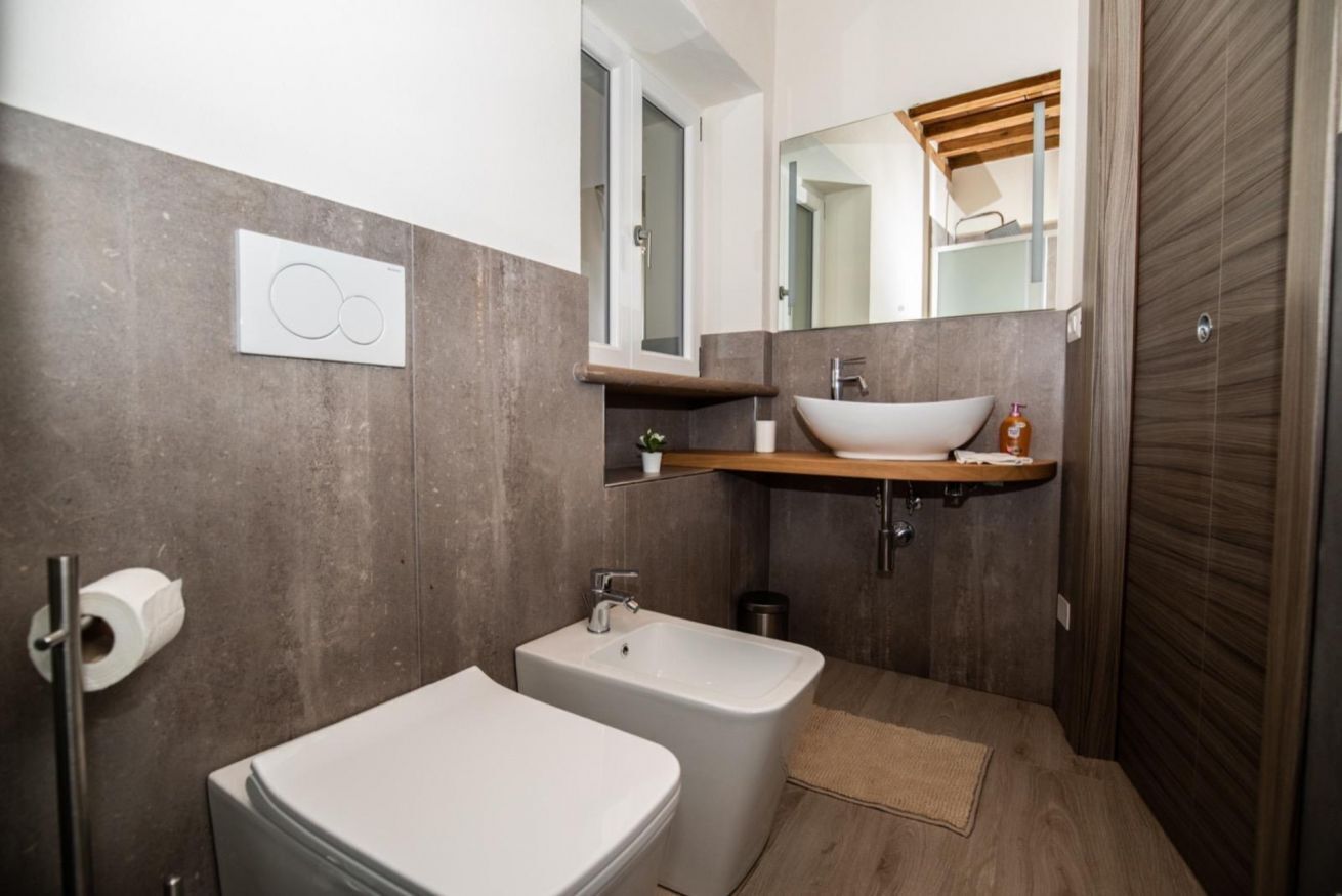 Une salle de bain moderne équipée de toilettes, d’un bidet et d’un lavabo.