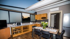 Een moderne keuken met een eethoek, grote ramen en uitzicht op de omgeving.