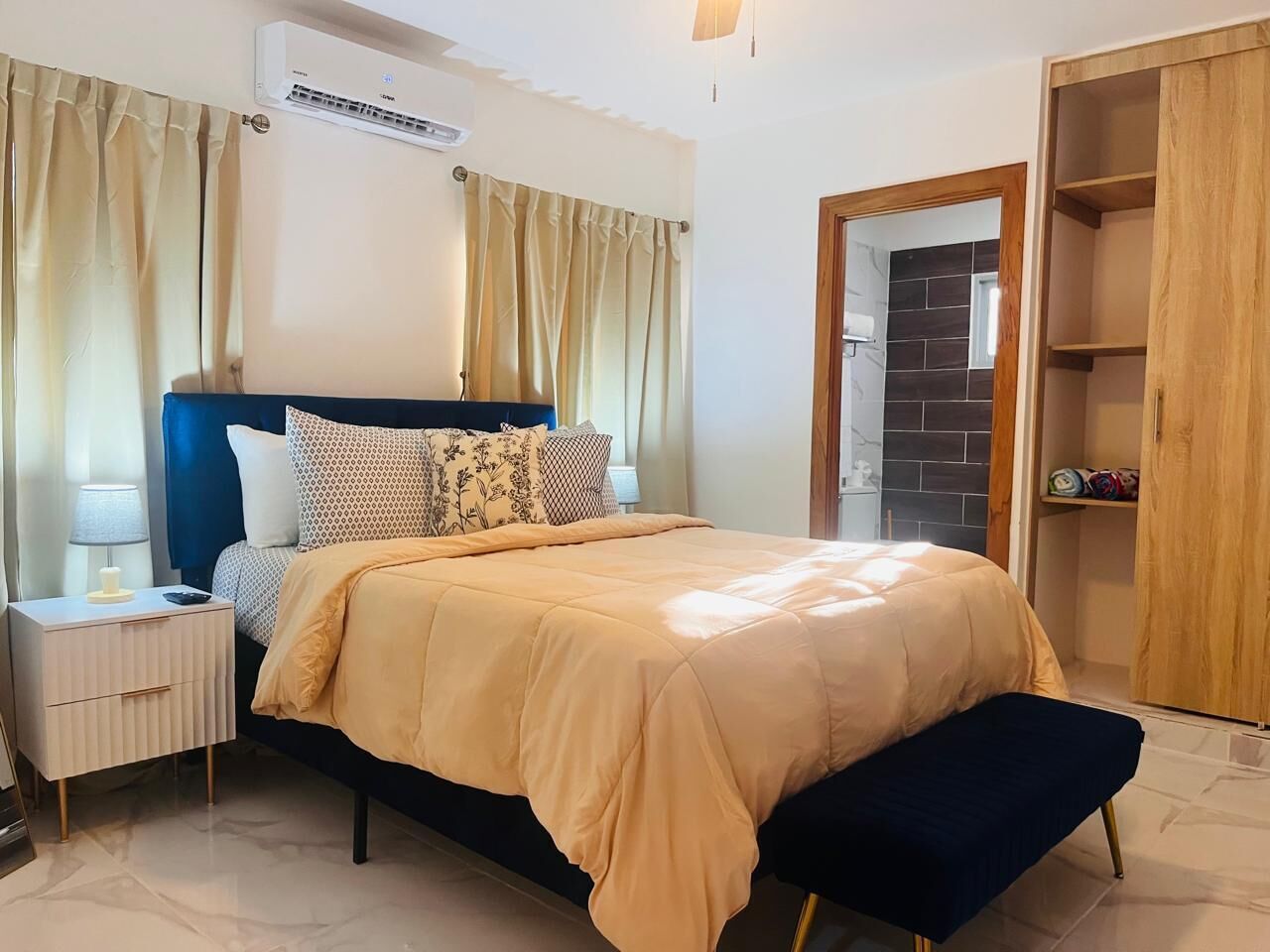 A bedroom with a bed, bedside tables, a wardrobe, and a curtain.