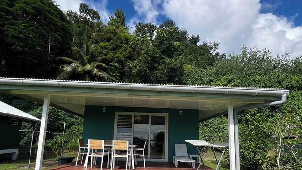 A house with a covered patio, a sliding glass door, and a small outdoor seating area with chairs and a table.