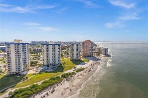 A coastal hotel complex with multiple high-rise buildings, a beachfront, and a clear sky. - Private Balcony, Ocean View, Steps to the Beach - Sunsets & Sanddollars - Roelens (Fort Myers Beach)