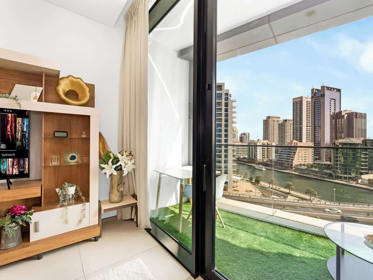 Een modern appartement met een groot raam met uitzicht op een stadsbeeld en een rivier.