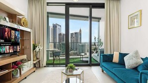 Un salon moderne doté d’une grande porte-fenêtre coulissante donnant sur un balcon avec vue sur la ville.