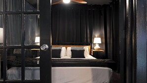 A hotel room with a large bed, two bedside lamps, a ceiling fan, and dark curtains. - 2BR The Montrose Serenity APT! Stroll & Relax ★★★★★ (Houston)
