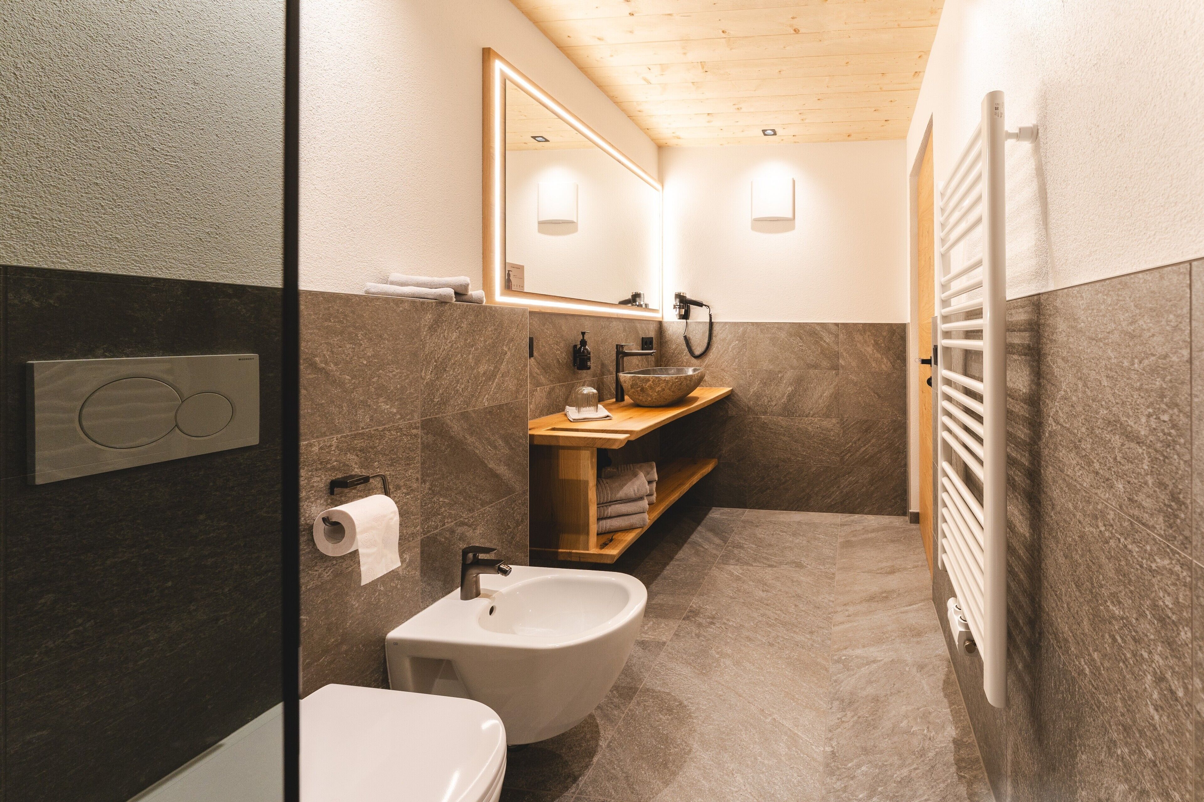 Ein modernes Badezimmer mit einer Bio-Toilette, Waschbecken und Spiegel.