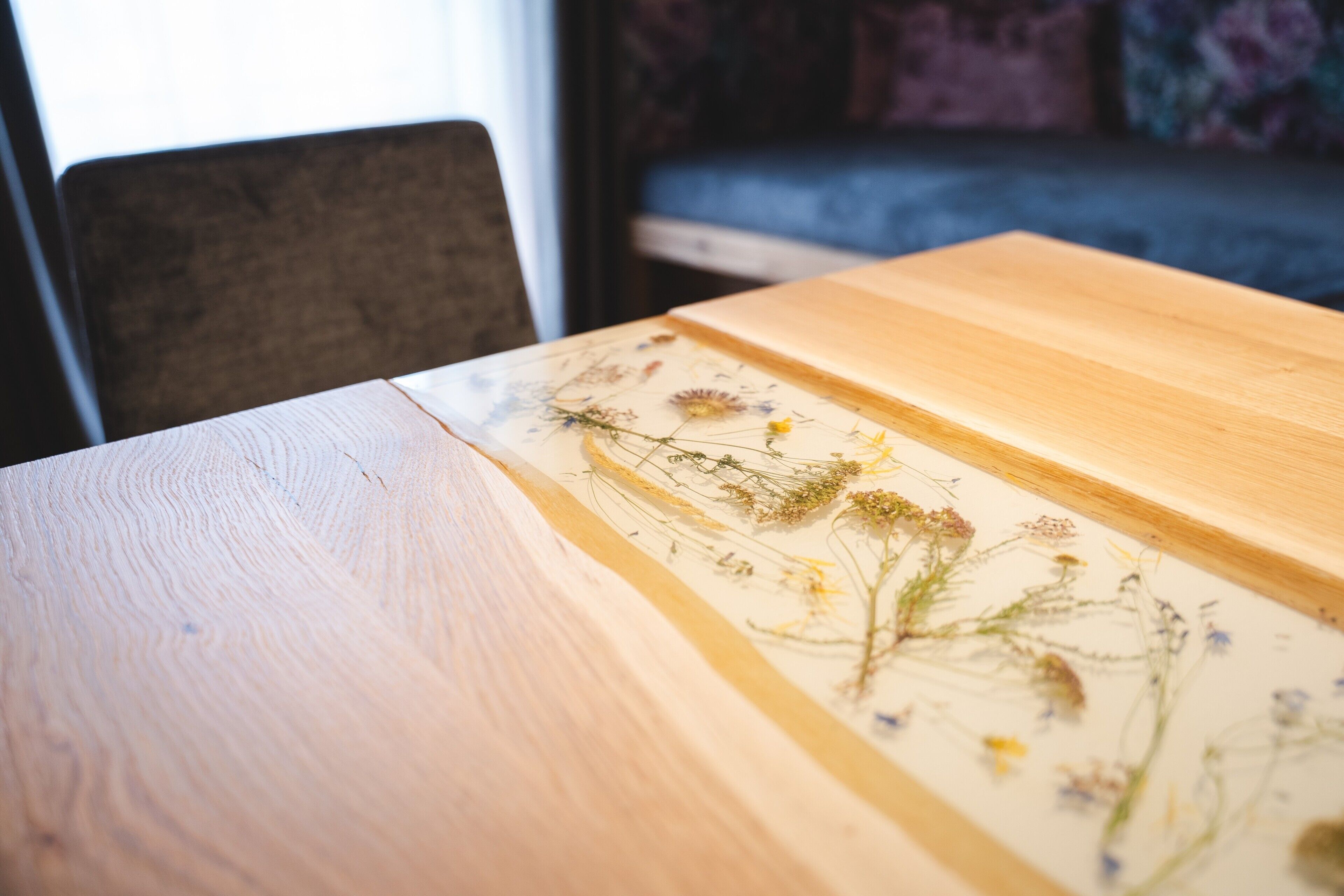 A wooden table with a floral print table runner.
