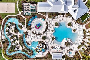 An aerial view of a resort with multiple swimming pools, a water park, and various lounge areas.