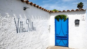 Ein weißes Gebäude mit blauer Tür, auf der Wand ist 'Villa Julia' geschrieben.