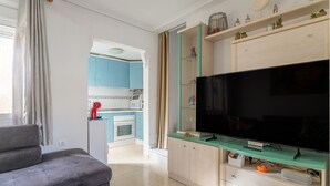 A living room with a sofa, a flat-screen TV, and a glass-top coffee table. - Holiday Home 'Horizon Oasis' with Sea View, Wi-Fi and Air Conditioning (Santa Pola)