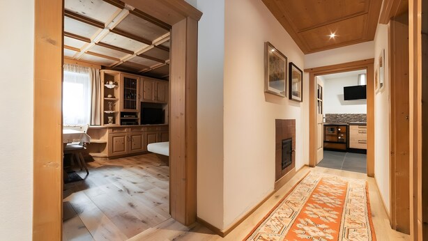 Un interior de madera con comedor, cocina y chimenea.