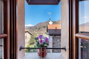 A balcony with a potted plant and a view of a mountain.