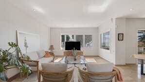 A spacious living room with a glass coffee table, wicker chairs, a sofa, and a flat-screen TV. - Vacation Villa 'Spinnaker Playa' with Sea View, Private Terrace and Wi-Fi (Santiago del Teide)