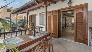 An outdoor patio with a wooden table, chairs, and a potted plant. - Vacation Villa 'Spinnaker Playa' with Sea View, Private Terrace and Wi-Fi (Santiago del Teide)