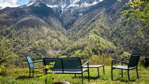 Bancos y sillas con vistas a un paisaje montañoso bajo un cielo despejado.