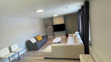 Een moderne woonkamer met een bank, een lange bank en een salontafel.