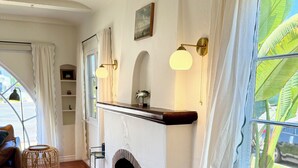 A cozy room with a fireplace, a dining table, and a view of the outdoors. - Charming, Historic 2-bedroom house in Coronado…28+ day discount (Coronado)