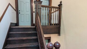 Una escalera de madera con barandilla y una puerta azul claro en la parte superior.