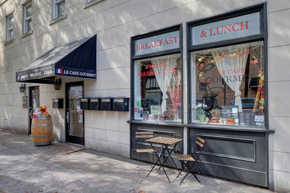 A cafe with a sign reading "BAKERY - BREAKFAST - LUNCH" and a menu display.