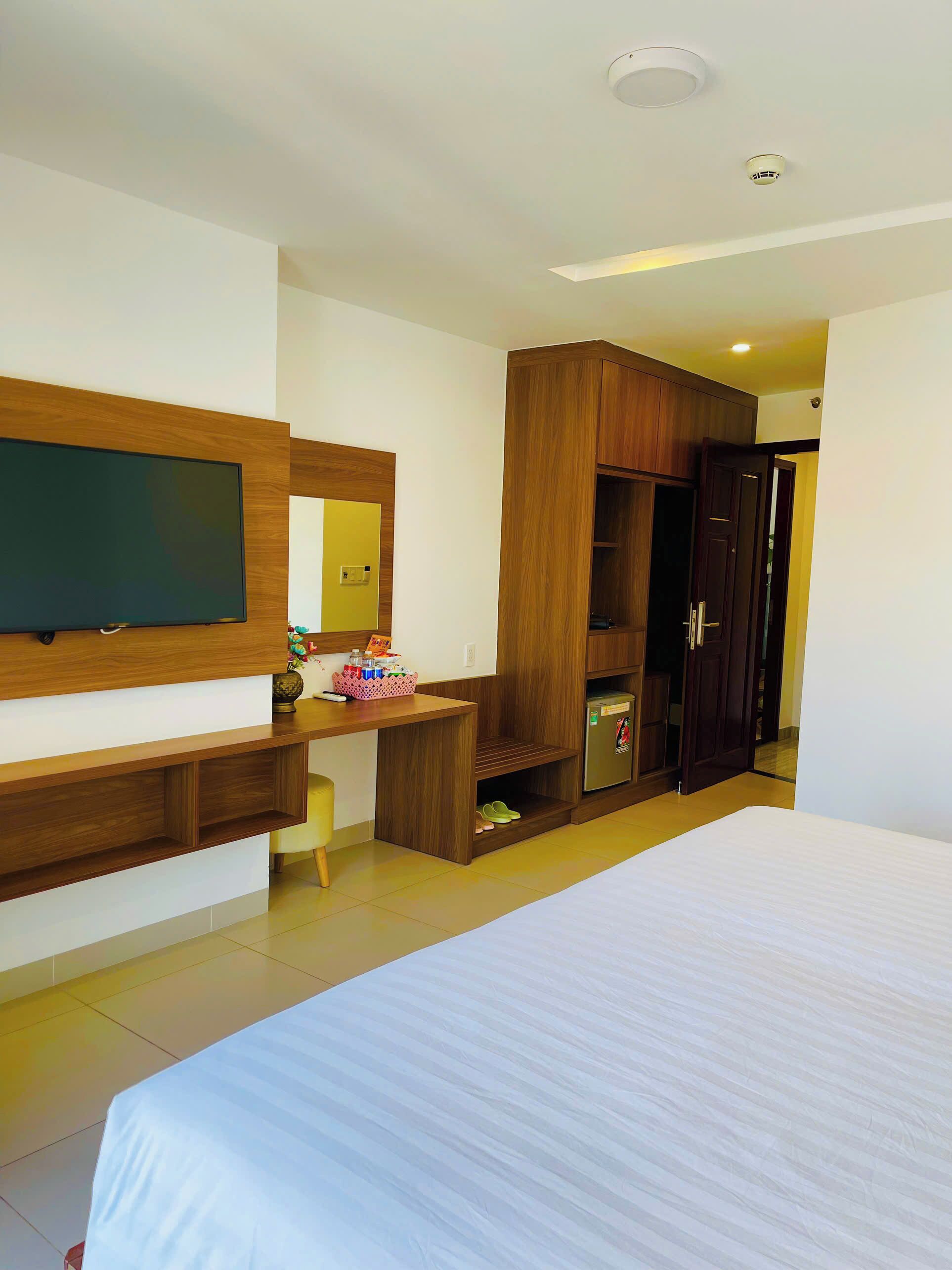 Ein Hotelzimmer mit Bett, Schreibtisch inklusive Computer, Kleiderschrank und Fernseher.