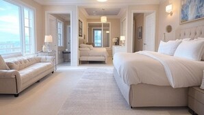 Une chambre spacieuse avec un grand lit, un canapé et une vue sur l’extérieur.