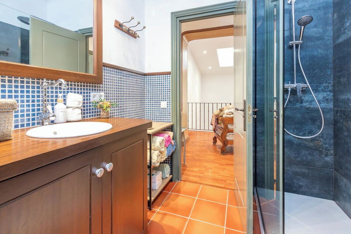 Une salle de bain avec un lavabo, un miroir et une douche.