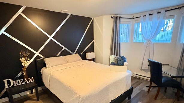 A modern bedroom with a bed, a desk, and a chair.