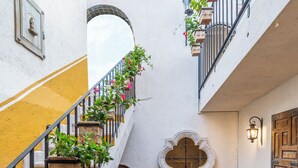 Ein mehrgeschossiges Interieur mit einer Treppe, schwarzen Geländern und Zimmerpflanzen.