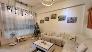 A modern living room with a Christmas tree, a sofa set, a coffee table, and artwork on the walls. - Bliss inn (Yuli)