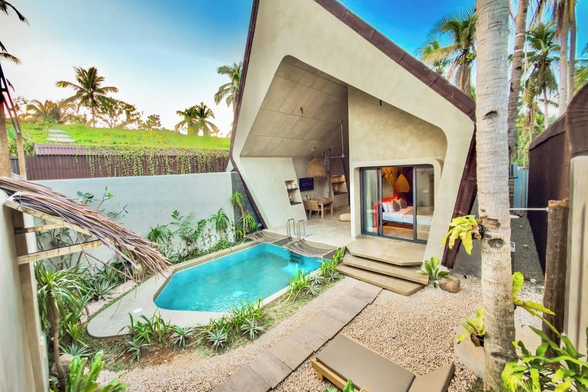 Una casa moderna con piscina, mobiliario exterior y vistas del paisaje circundante.