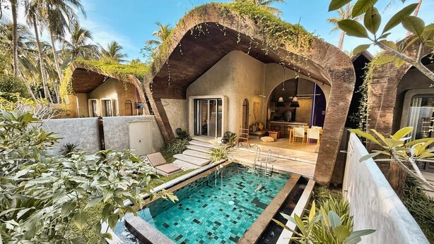 Un espace piscine doté d’une terrasse carrelée, d’un coin salon abrité et d’une vue sur la piscine.