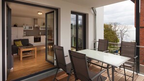 Un appartement moderne doté d’un balcon, d’un coin repas et d’une cuisine.