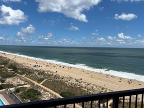 Une plage avec une zone délimitée par une clôture, une piscine et un ciel dégagé.