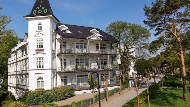 Un immeuble à plusieurs étages, doté de balcons et surmonté d’une tour.
