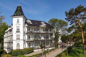 Un immeuble à plusieurs étages, doté de balcons et surmonté d’une tour.