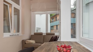 Une pièce chaleureuse avec une table à manger en bois, un canapé beige et un bol de cerises.