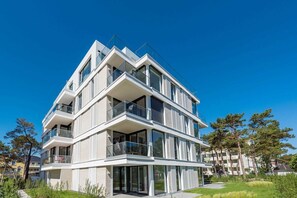Un immeuble moderne à plusieurs étages, doté de balcons et de grandes fenêtres.