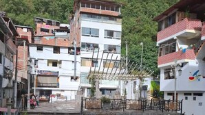 Un patio con una escalera de piedra que lleva a la entrada de un edificio, rodeado de edificios de varios pisos y vegetación.