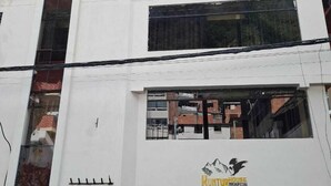 Un edificio de varios pisos con un letrero que dice "Hunting House Machupicchu".