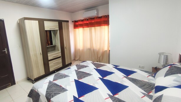 A bedroom with a bed, wardrobe, and a window with curtains. - Charming 1-bedroom apartment in lovely Santa Cruz with WiFi, AC (Santa Cruz de la Sierra)