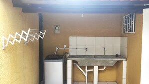 A compact kitchen with a washing machine, a sink, and a drying rack. - Charming 1-bedroom apartment in lovely Santa Cruz with WiFi, AC (Santa Cruz de la Sierra)