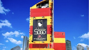 Un edificio alto y colorido con un letrero llamativo que anuncia un hotel.