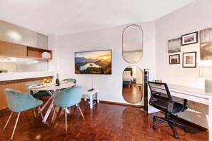 A modern kitchen with a dining area, a large mirror, and a painting on the wall. - La Perla Sul Lago - Studio with Balcony View, Paradiso (Lugano), Switzerland (Paradiso (Lugano))