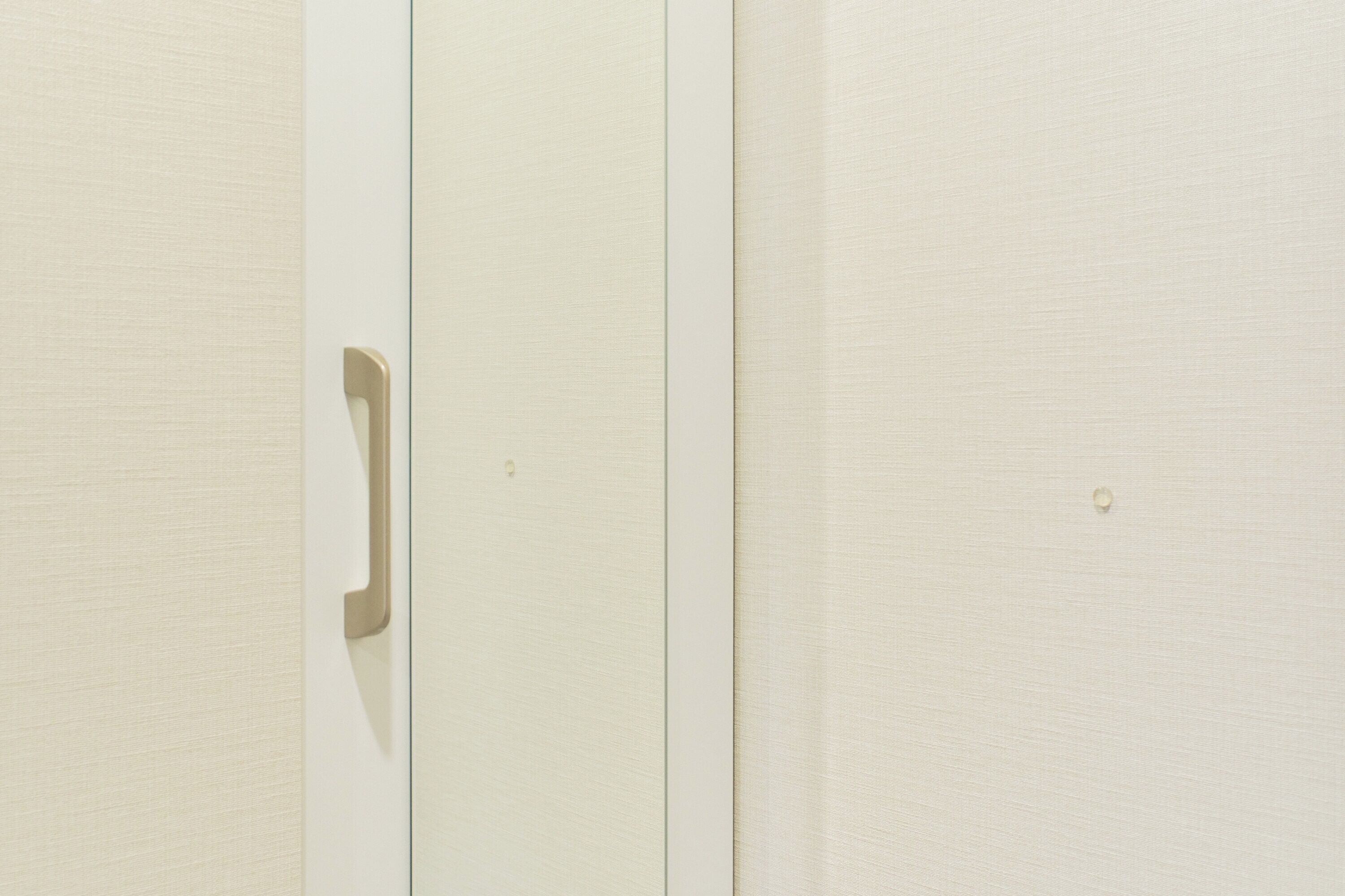 A white door with a handle, a visible lock, and a small hole in the door.